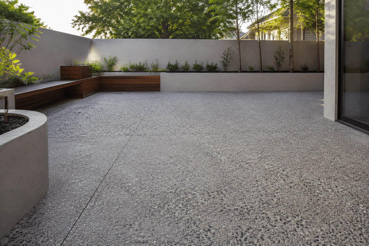 textured aggregate courtyard with neat garden edges and an outdoor bench
